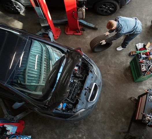 Vue de dessus d’un mécanicien réparant une voiture dans un centre de service.
